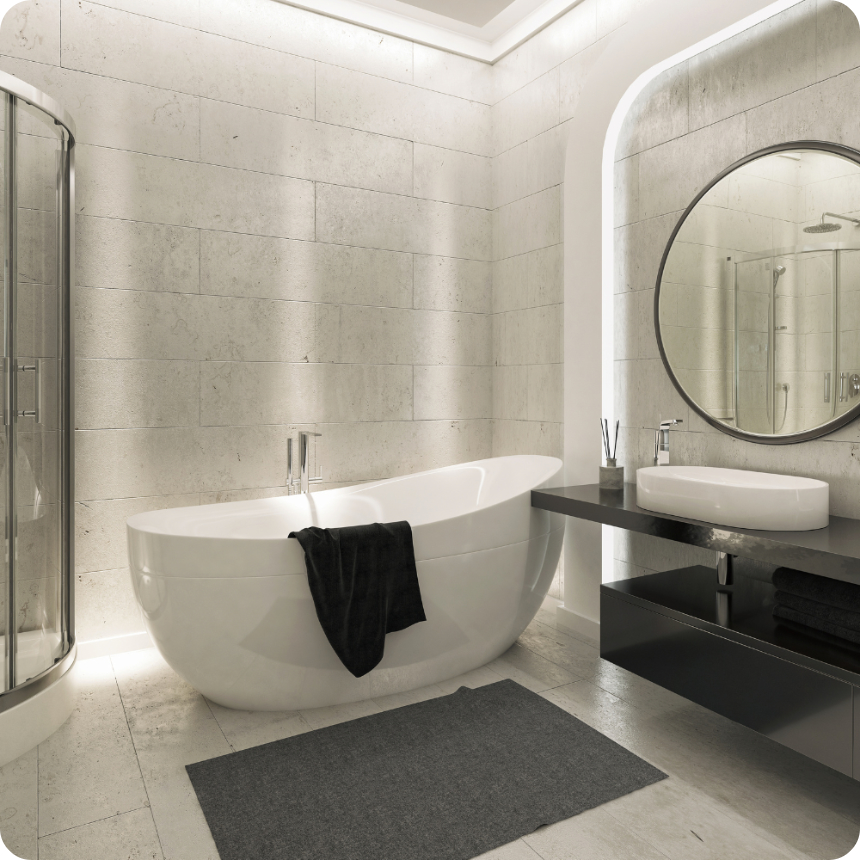 Modern bathroom with a freestanding bathtub, round mirror, sink on a black counter, and glass shower enclosure, all set against light stone walls.